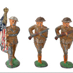 Three Barclay toy soldiers with American flags and rifles on a white background