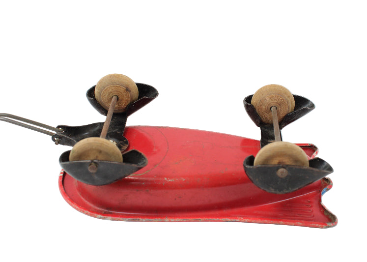 Vintage-style red metal tool with wooden handles on a white background