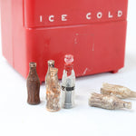 Red cooler labeled 'Ice Cold' with vintage-style soda bottles on a white background