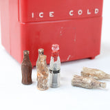 Red cooler labeled 'Ice Cold' with vintage-style soda bottles on a white background