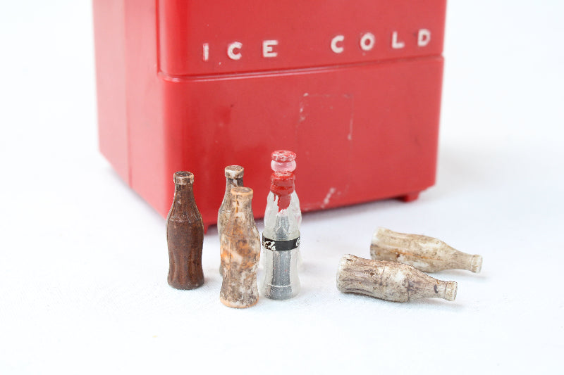 Red cooler labeled 'Ice Cold' with vintage-style soda bottles on a white background