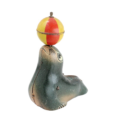 Seal figurine with a colorful ball on its head against a white background