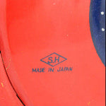 Red toy rocket with a colorful wheel design on a white background