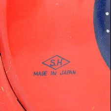 Red toy rocket with a colorful wheel design on a white background