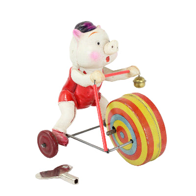 Toy pig riding a tricycle with colorful wheels on a white background