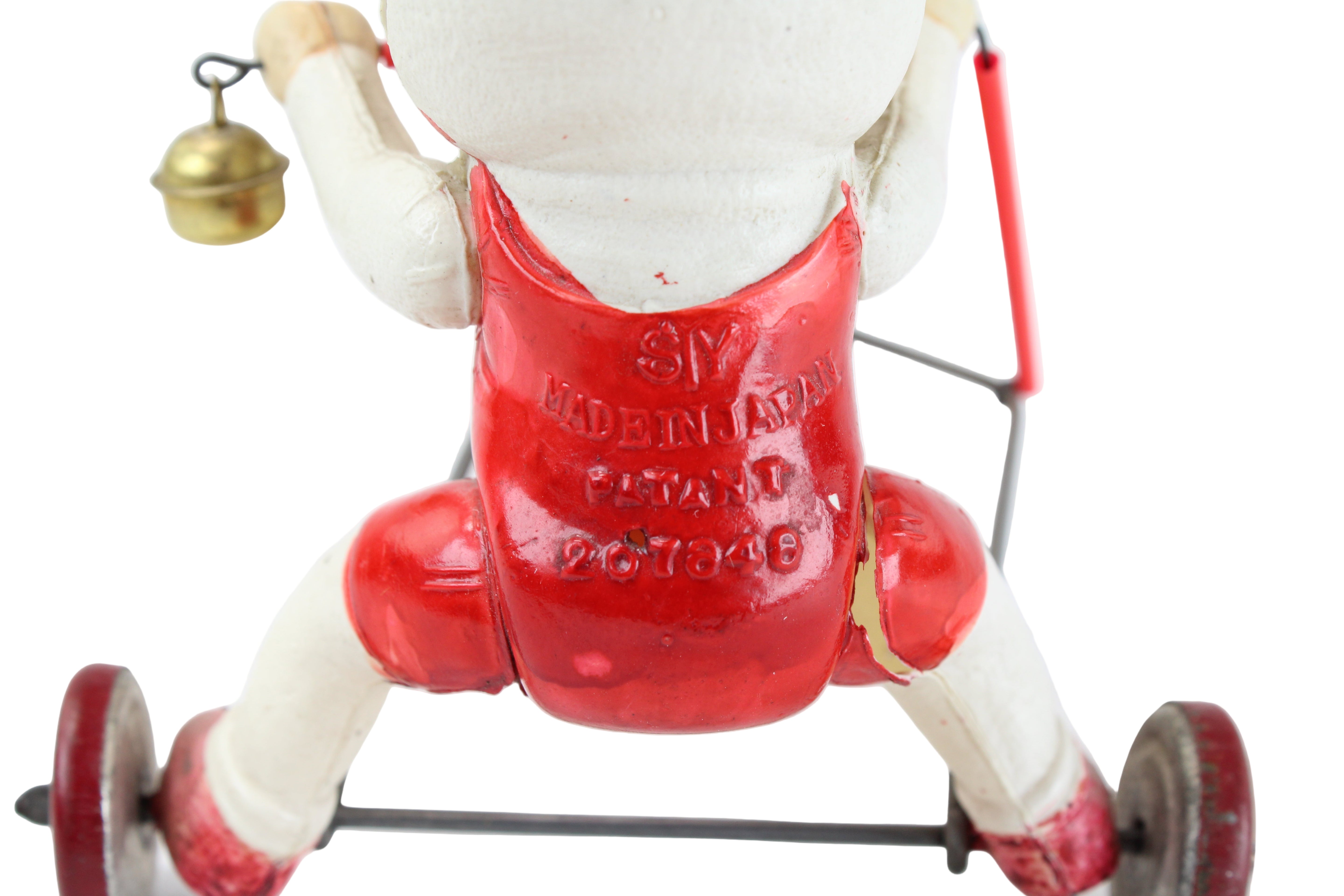 Vintage toy figure with red apron and wheels on a white background