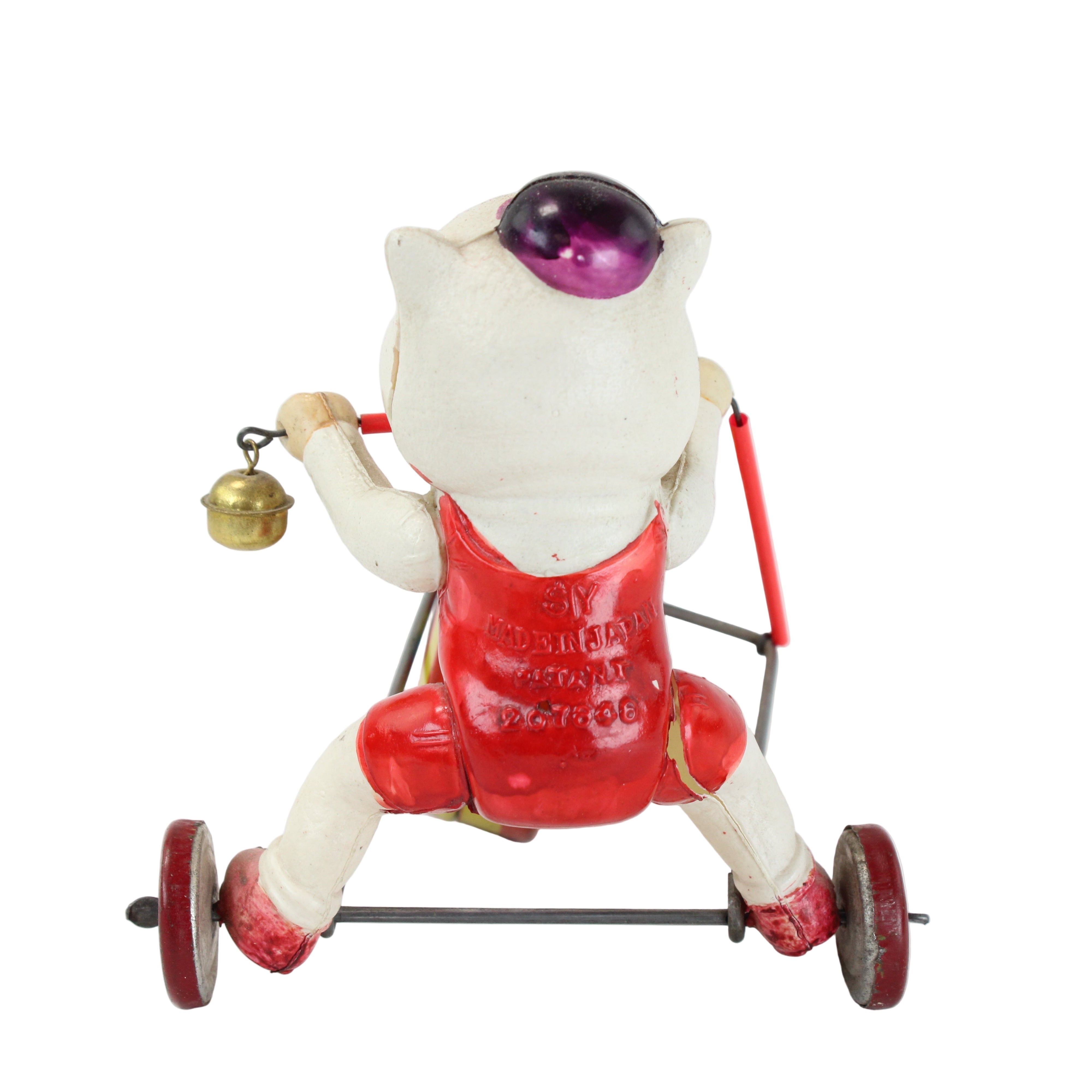 Vintage toy cat on a scooter with a bell on a white background