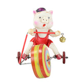 Toy pig on a unicycle with colorful wheel and bell, on a white background