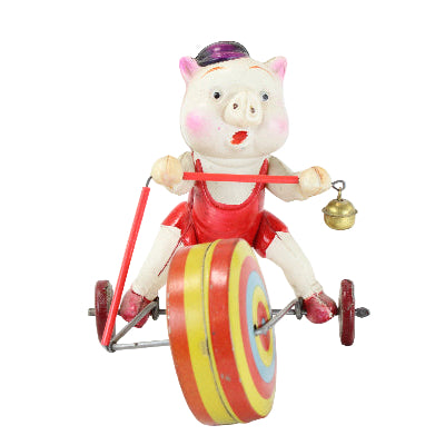 Toy pig on a unicycle with colorful wheel and bell, on a white background