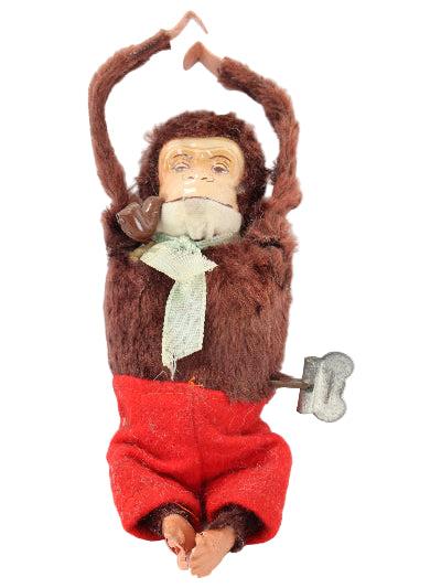 Stuffed monkey toy with a white hat and red pants on a white background