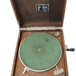 Vintage record player with wooden casing and green vinyl record on a white background