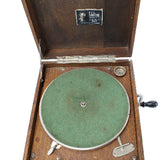 Vintage record player with wooden casing and green vinyl record on a white background