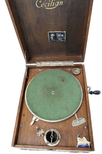 Vintage record player with wooden casing and green vinyl record on a white background