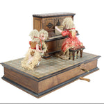 Miniature wooden stage with dolls and furniture on a white background