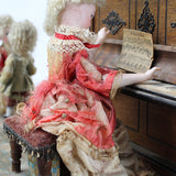 Vintage-style doll with intricate clothing and accessories on a textured surface