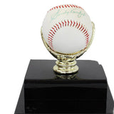 Signed baseball on a black base with gold stand against a white background
