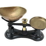 Vintage-style scale with brass bowls on a white background