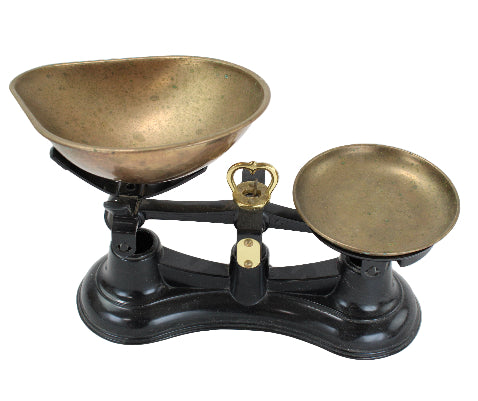 Vintage-style scale with brass bowls on a white background
