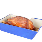 Roasted chicken in a blue roasting pan on a white background