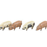 Four small pig figurines on a white background