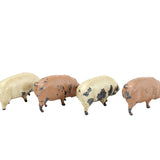 Four small pig figurines in different colors on a white background