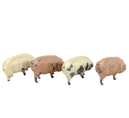 Four small pig figurines in different colors on a white background
