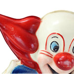 Close-up of a clown figurine with a red nose and blue eyes on a white background