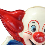 Close-up of a clown figurine with a red nose and blue eyes on a white background