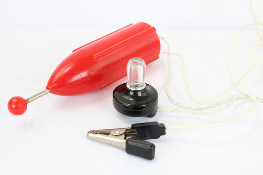 Red plastic float, clear light bulb, and black alligator clips on a white background