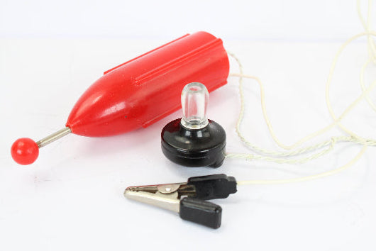 Red plastic float, clear light bulb, and black alligator clips on a white background