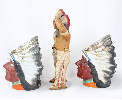 Three Native American figurines with headdresses on a white background