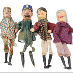 Four vintage dolls in different outfits on a white background