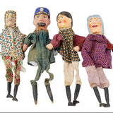 Four vintage dolls in different outfits on a white background