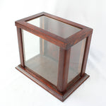 Wooden display case with glass front on a white background
