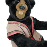 Black bear toy wearing a decorative harness on a white background