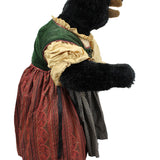 Stuffed bear in a vintage outfit with a green hood and red dress on a white background