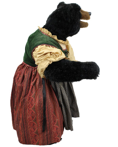 Stuffed bear in a vintage outfit with a green hood and red dress on a white background