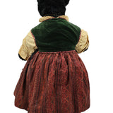 Vintage doll with a green velvet hat and red dress on a white background
