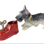 Toy dog standing next to a red shoe with a key on a white background