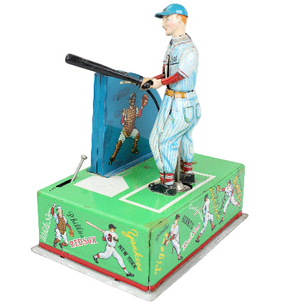 Vintage toy figure of a baseball player with a green box featuring baseball-themed illustrations on a white background.