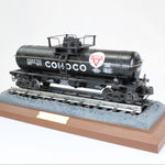 Model train car on a wooden base with a white background