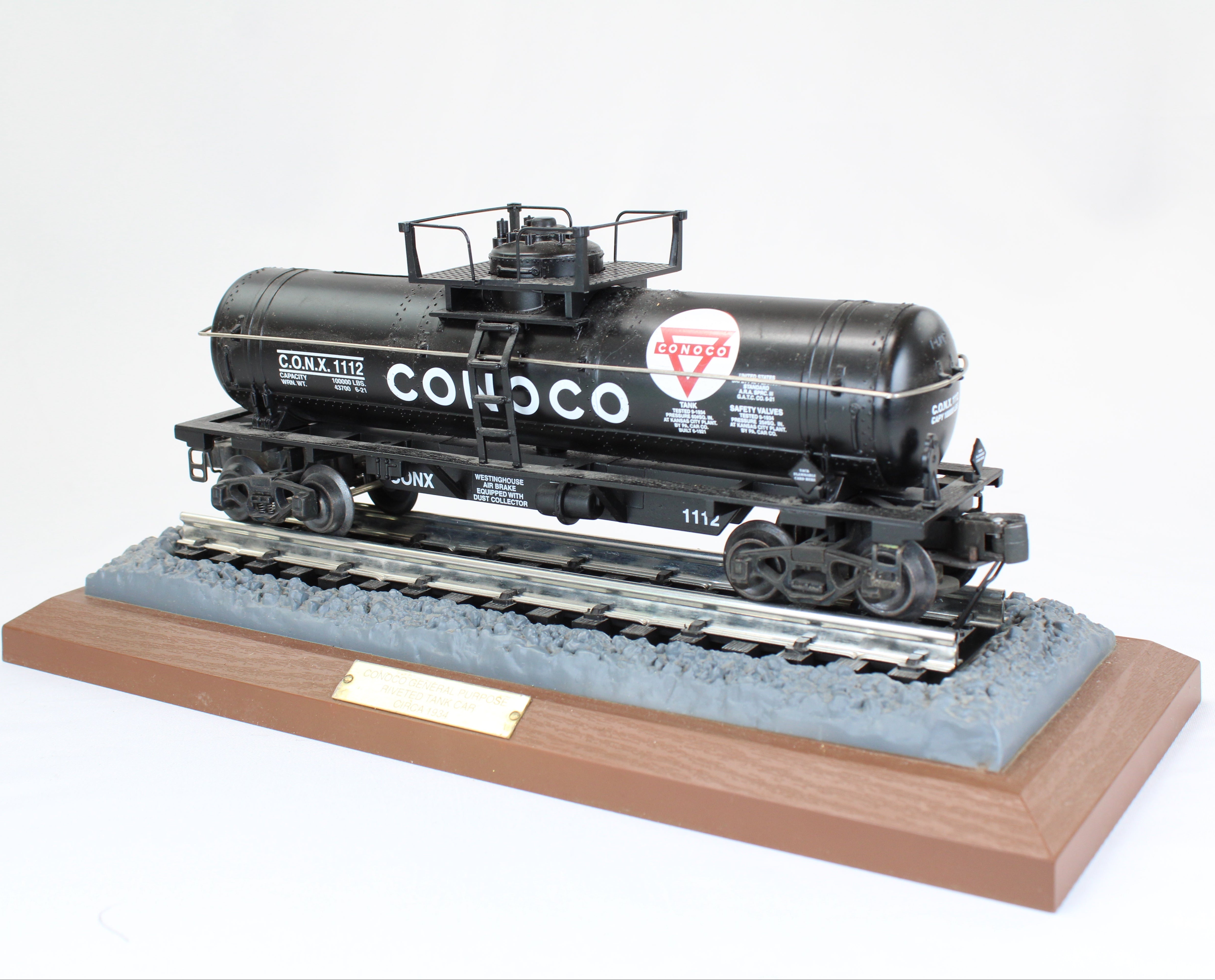 Model train car on a wooden base with a white background