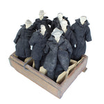 Set of mannequins in dark coats displayed in a wooden crate on a white background