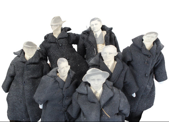 Set of mannequins dressed in dark coats and hats on a white background