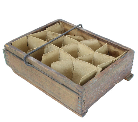 Wooden box with compartments containing triangular brown objects on a white background