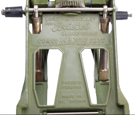 Close-up of a green mechanical device with engraved text on a white background