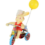 Toy figure of a bear on a unicycle with a yellow ball attached, on a white background