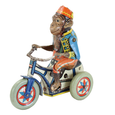 Toy monkey on a tricycle with colorful design on a white background