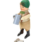 Vintage toy figure of a person with a green hat and brown outfit on a white background