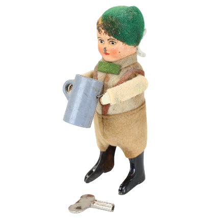 Vintage toy figure of a person with a green hat and brown outfit on a white background